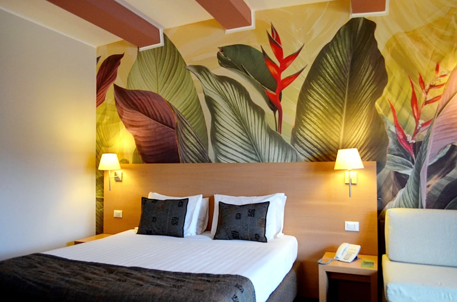 Carta da parati camera hotel con foglie grandi verdi